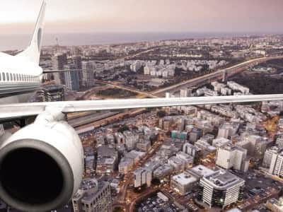 Fototapete Flugzeug über einer Großstadt