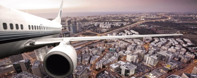 Fototapeta Flugzeug über einer Großstadt
